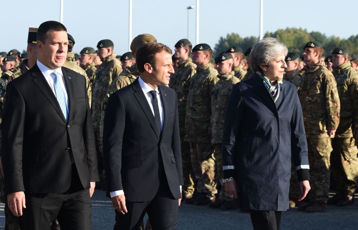 (L-R) Estonian Prime Minister Juri Ratas, French President Emmanuel Macron and British Prime Minister Theresa May inspect troops as they visit an Estonian military base in Tapa on the sidelines of a European Union summit