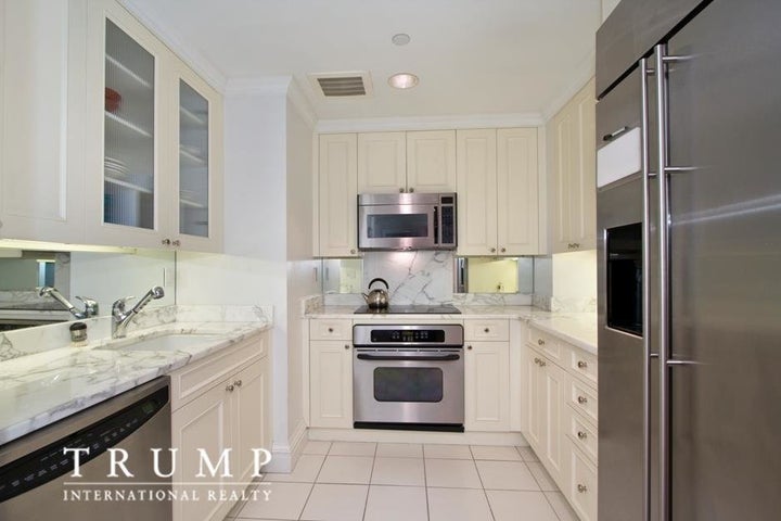 The kitchen has white marble counters and floors.