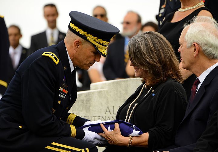 Maj. Gen. Michael S. Linnington, Joint Force Headquarters-National Capital Region/Military District of Washington, commanding general, hands a flag to Barbara Broyles, during the funeral of her father, Lt. Col. Faith Jr., in Arlington National Cemetery, Arlington, Va., in 2013. 
