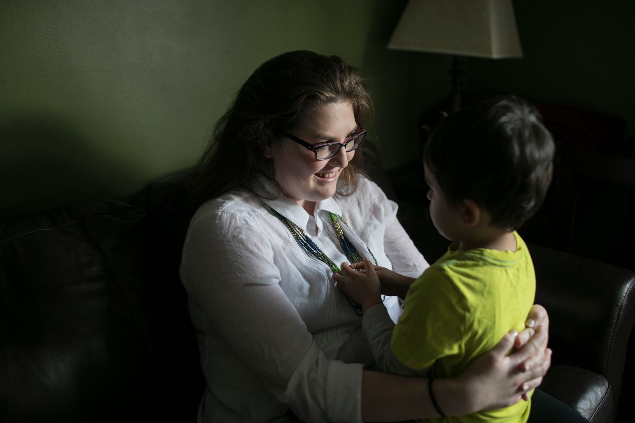 Tiffany Ann Stacy holds her son at home in Cuyahoga Falls, Ohio. Stacy, born in the U.S., lives with her husband from Nepal, their children and his parents.
