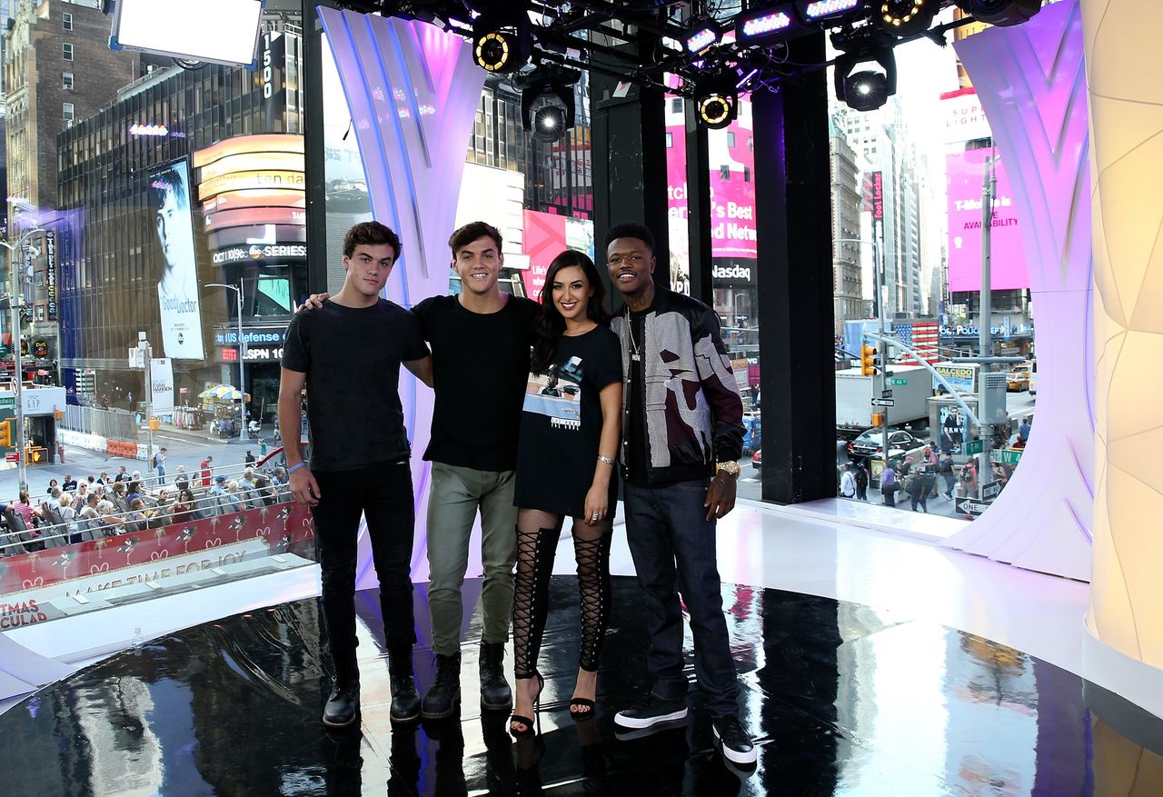 "TRL" squad members Ethan Dolan, Grayson Dolan and Tamara Dhia with "TRL" host DC Young Fly in front of the MTV studio's iconic floor-to-ceiling windows.