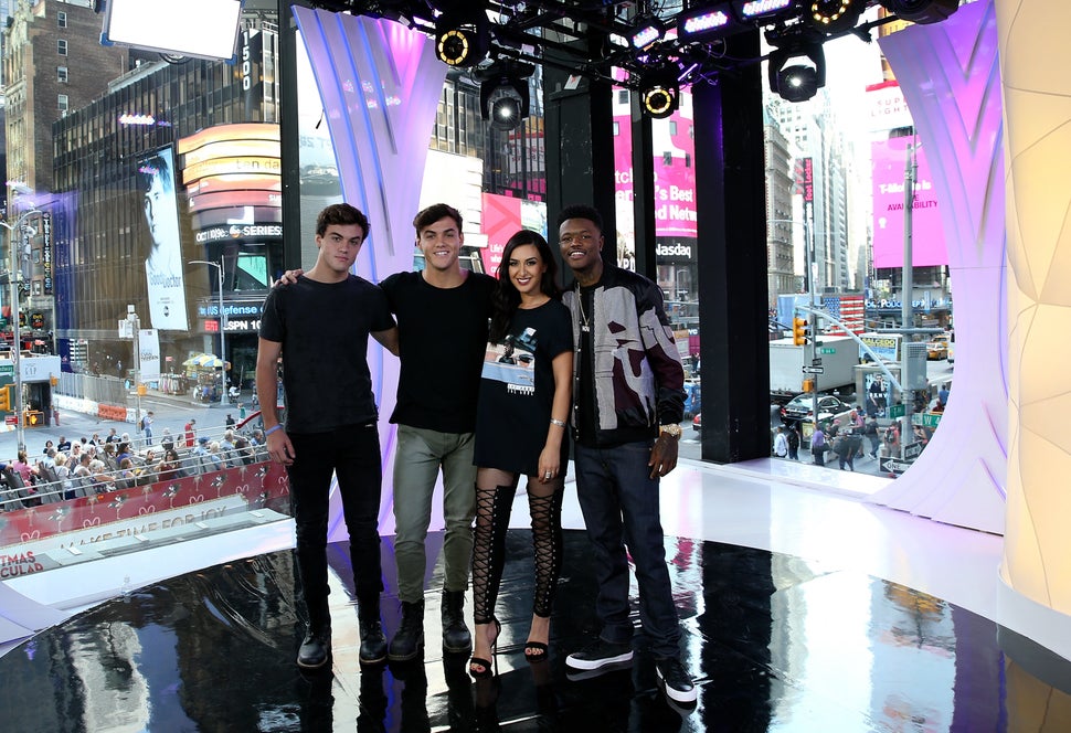 "TRL" squad members Ethan Dolan, Grayson Dolan and Tamara Dhia with "TRL" host DC Young Fly in front of the MTV studio's icon