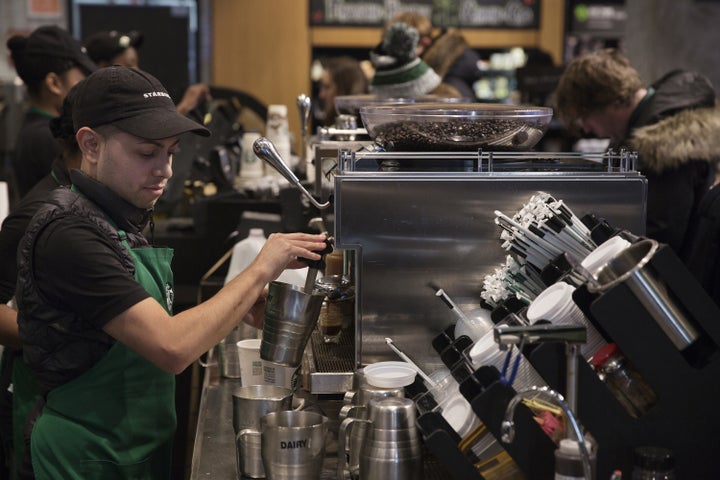 A barista froths milk for a drink inside a Starbucks shop in New York. Shareholders of the company are criticizing how its employee benefits are different for hourly workers and salaried workers.