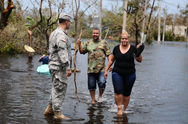 Citizen- Soldier help a couple getting away of the flooded areas in Condado, San Juan, Puerto Rico after the path of Hurricane Maria.