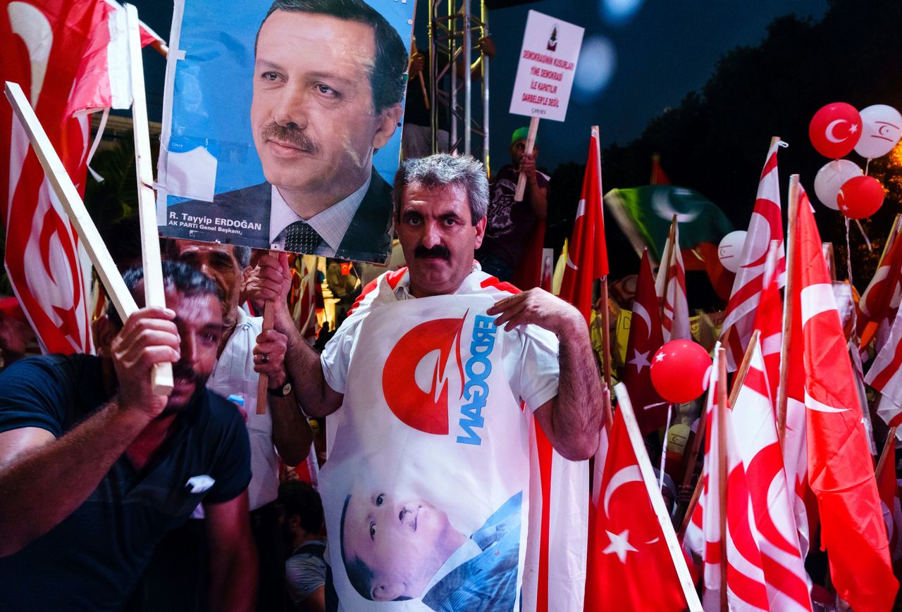 Turkish Cypriot demonstrators wave Turkish and Turkish Cypriot flags during a mass rally in support of Turkey's Erdogan following a failed coup that aimed to oust him.