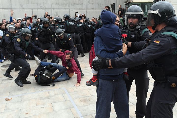 <strong>A man (back) struggles with the police as other police take hold of a man and a child holding a red flower as they move in on the crowds</strong>