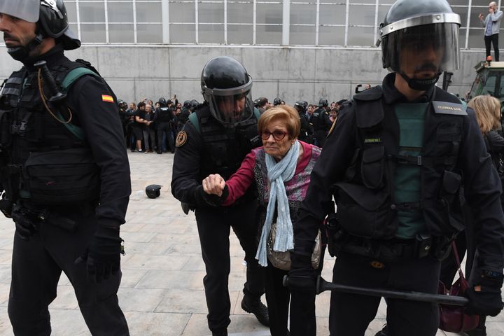An elderly woman is removed by police