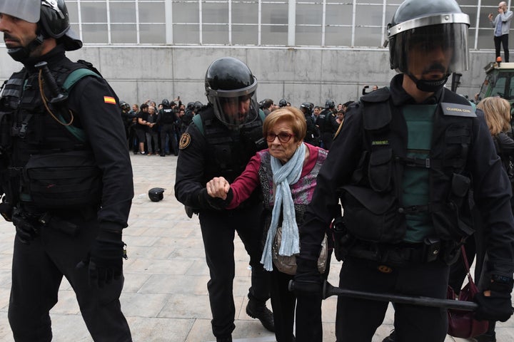 <strong>An elderly woman is removed by police</strong>