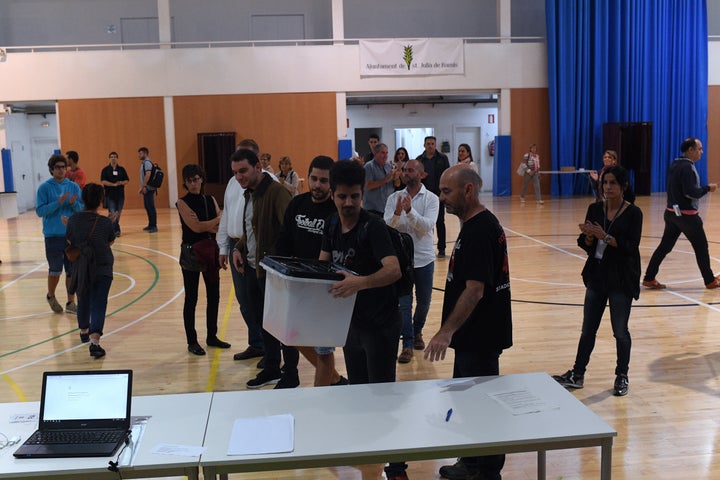 Ballot boxes arrive at the polling station where Carles Puigdemont was expected to vote. He later voted elsewhere because of the police intervention.