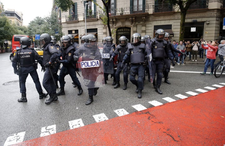 Police officers walk in the street after seizing ballot boxes in a polling station in Barcelona