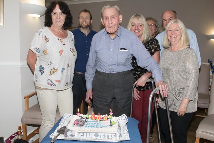 Ernest celebrating his 100th birthday with friends, family and cake.