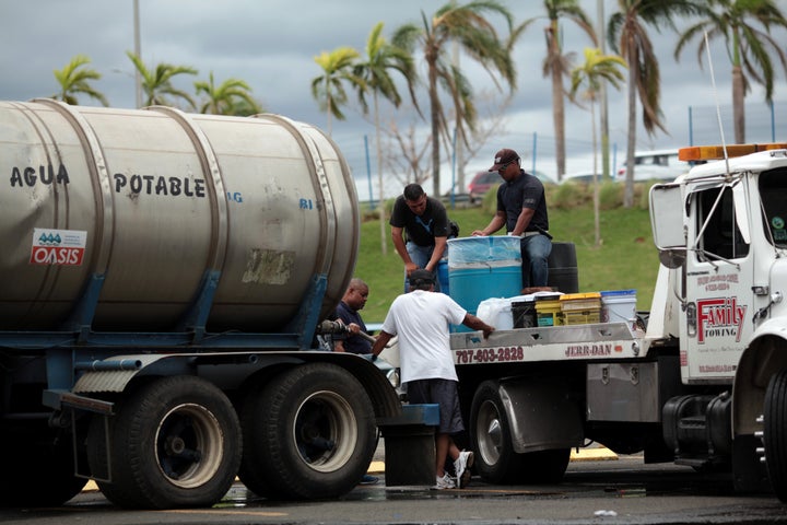 Local residents fill cans of water in Carolina, Puerto Rico, on Saturday.