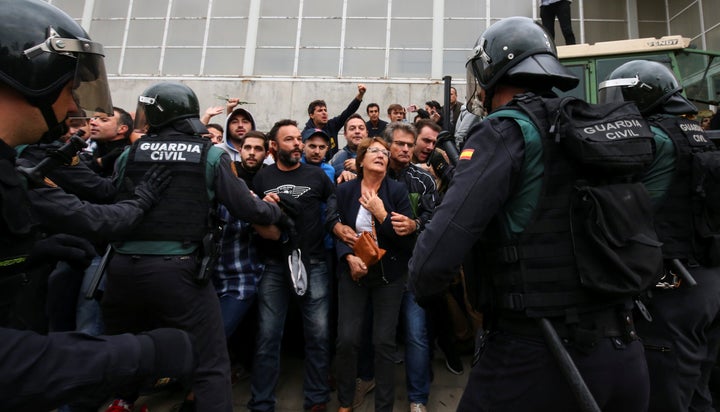 People confront Spanish Civil Guard officers outside a polling station for the banned independence referendum in Sant Julia d