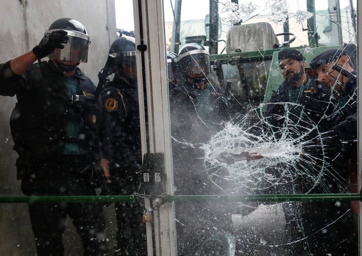 Spanish Civil Guard officers break through a door at a polling station for the banned independence referendum on Oct. 1, 2017.