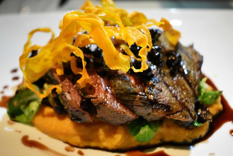 Venison medallions served atop mashed sweet potatoes and huckleberries.