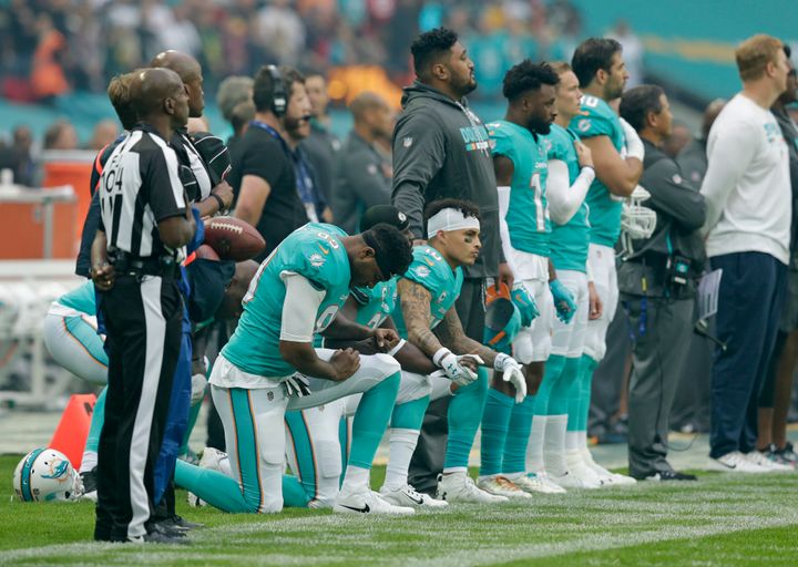 Dolphins players Kenny Stills, Michael Thomas and Julius Thomas kneel before their Sunday game in London, England.