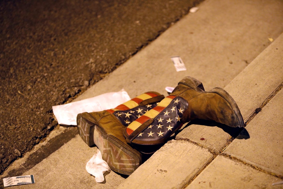 A pair of cowboy boots is shown in the street outside the concert venue