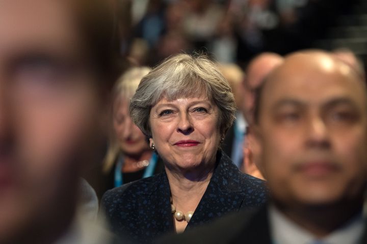 Theresa May, listens to a speech by Philip Hammond