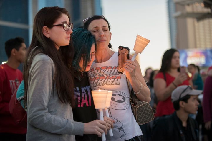 Mourners comfort each other during a candlelight vigil held on the north end of the Las Vegas strip across the street from the SLS hotel and casino on Oct. 2, 2017.