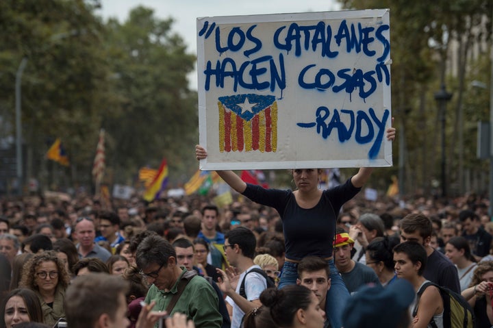 A demonstrator holds up a sign that reads a quote from the Prime Minister of Spain Mariano Rajoy: 'Catalans do things.'