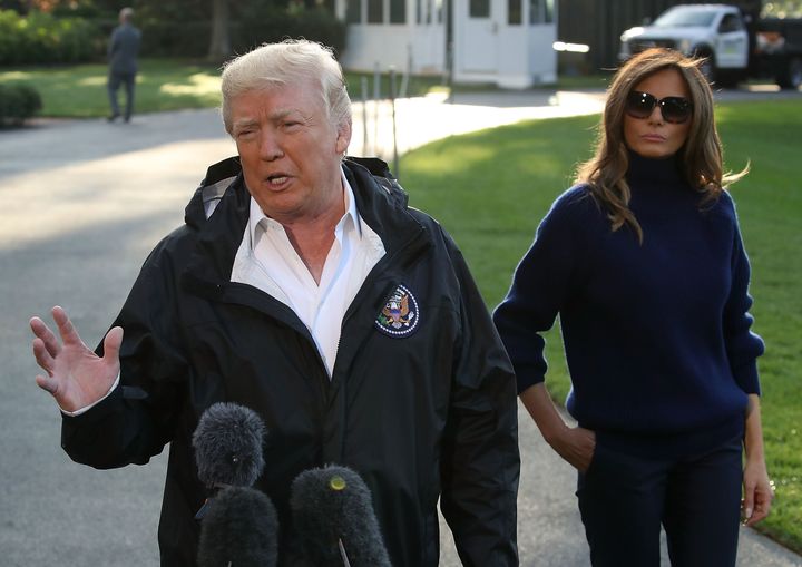 US President Donald Trump speaks to the media while flanked by First Lady Melania Trump before departing on Marine One from the White House.