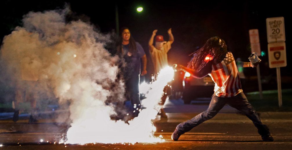 Edward Crawford tosses a tear gas canister fired by police who were trying to disperse protesters in Ferguson, Missouri, on Aug. 13, 2014. 