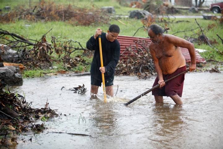 Residents of St. Croix work in floodwaters to clear a drain blocked by debris from Hurricane Maria as the island receives torrential rains on Sept. 30, 2017.