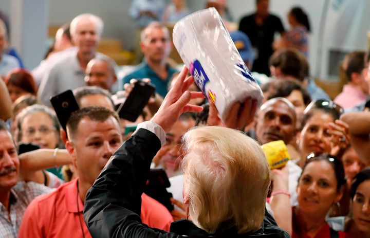 President Donald Trump throws rolls of paper towels to a crowd of local residents affected by Hurricane Maria as he visits a disaster relief distribution center Tuesday in San Juan, Puerto Rico.