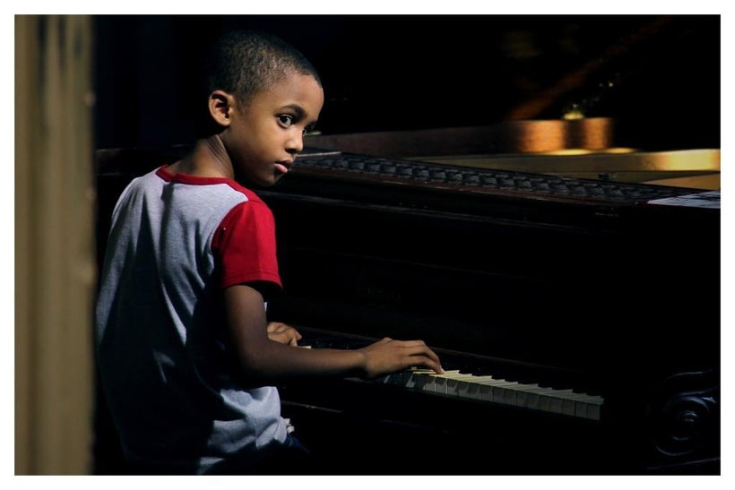 Reynaldo Guanche takes a piano lesson in a scene from <strong><em>Esteban</em></strong>