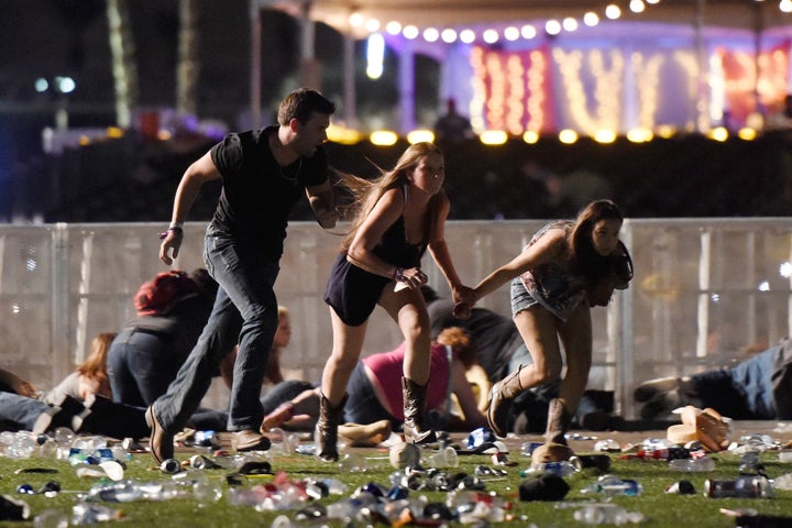 People run from the Route 91 Harvest country music festival in Las Vegas Sunday night after gunfire was heard.