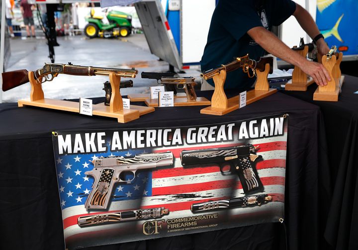 A worker rearranges the guns inside the booth at Commemorative Firearms as fans stopped by to check out guns bearing Trump's motto: 'Make America Great Again' in Bristol, Tennessee