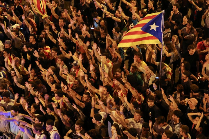 People raise arms and shout during a demonstration two days after the banned independence referendum in Barcelona, Spain, Oct