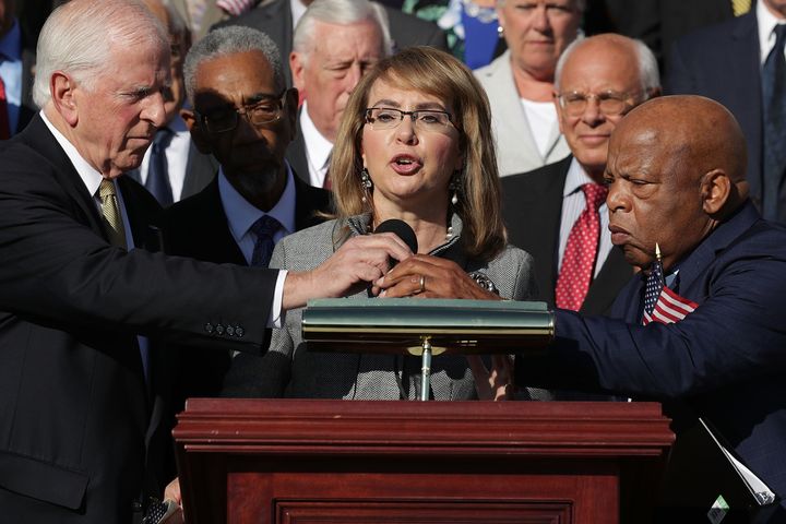 Gabby Giffords, who was serving in Congress when she was shot in 2011, addresses a rally with fellow Democrats after the Las Vegas mass shooting, calling for legislation to strengthen background checks 