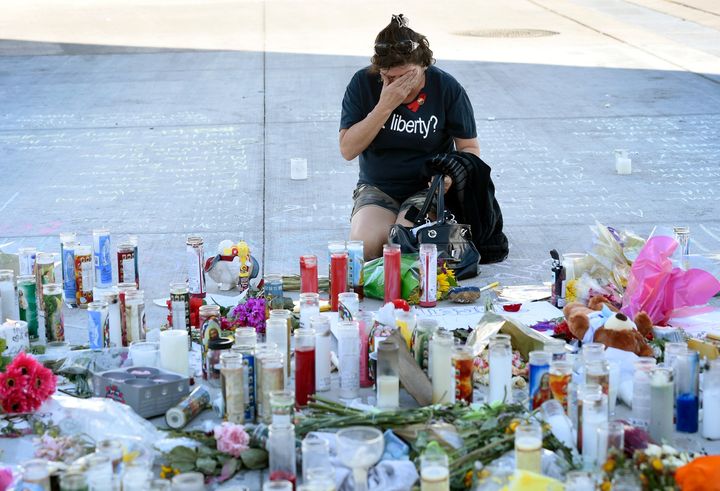 A woman wipes her eyes at a memorial on Las Vegas strip to those who died