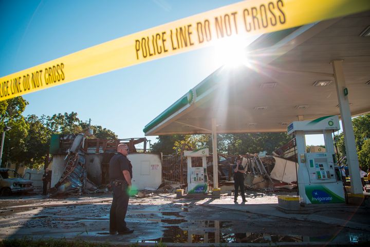 MILWAUKEE, WI - AUGUST 14: A police officer stands guard in front of the damage to the BP gas station after rioters clashed with the Milwaukee Police Department protesting an officer involved killing August 14, 2016 in Milwaukee, Wisconsin. Hundreds of angry people confronted police after an officer shot and killed a fleeing armed man earlier in the day. (Photo by Darren Hauck/Getty Images)