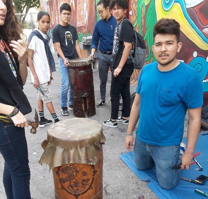 Antonio Tlaloc Carrillo, right, re-skinning a drum with other students at Semillas Community Schools in 2017.