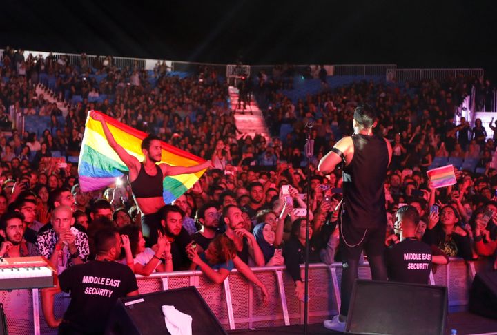 A fan of Lebanese alternative rock band Mashrou' Leila holds a rainbow flag during a 2017 concert. 