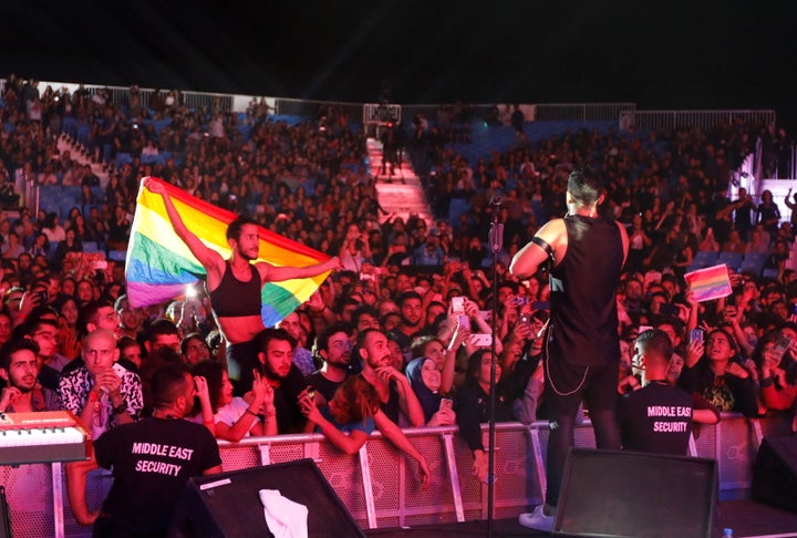 A fan of Lebanese alternative rock band Mashrou' Leila holds a rainbow flag during a 2017 concert. 