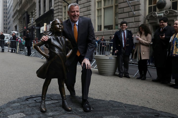 New York City Mayor Bill de Blasio poses next to the Fearless Girl statue in New York on March 27, 2017.