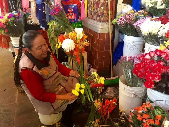 A woman assembles a bouquet at Mercado San Angel.