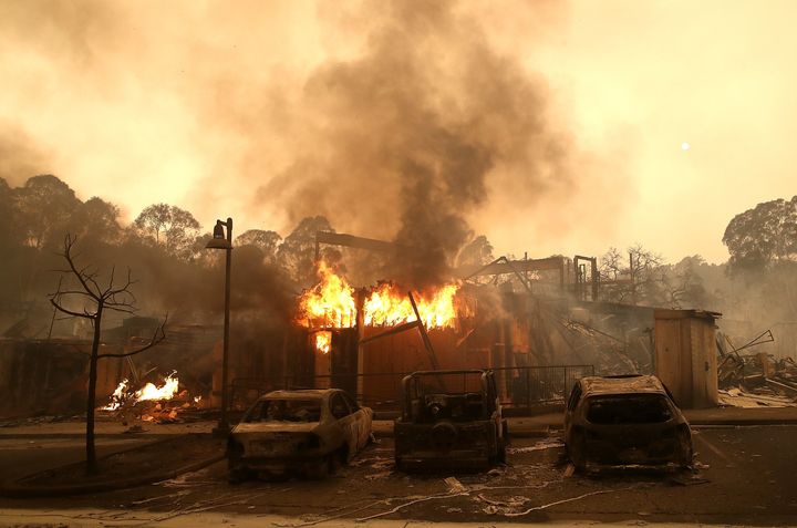 Burned out cars sit next to a building in fire in Santa Rosa, California; wildfires have killed at least 10 people in the state