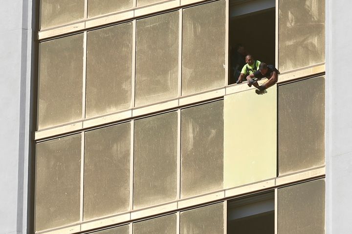 Workers board up a broken window at the Mandalay Bay hotel where Paddock unleashed his shooting spree