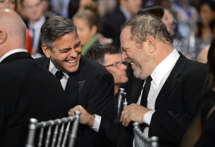 George Clooney and Harvey Weinstein share a laugh in 2013. Clooney called the accusations against Weinstein "disturbing" in part because many people may have covered them up.