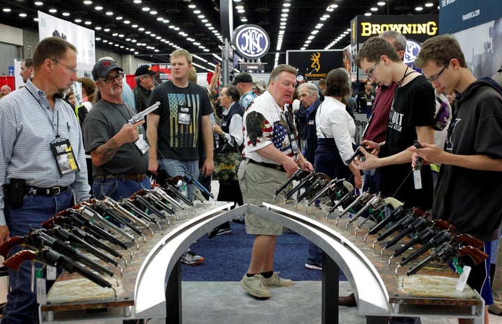 Gun enthusiasts look over Benelli USA guns at a National Rifle Association show in Louisville, Kentucky, May 21, 2016.