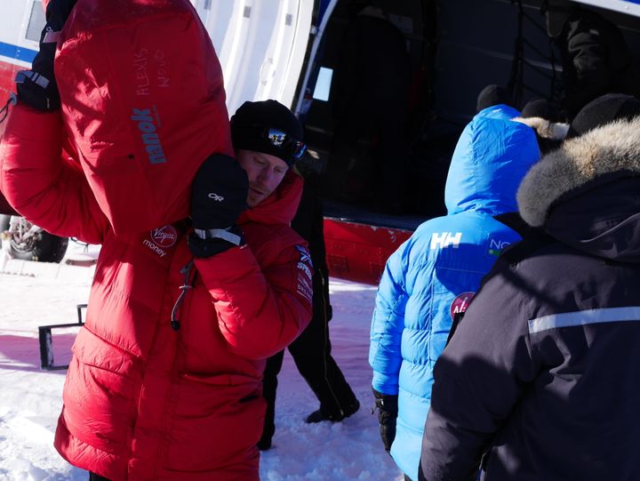 Prince Harry unloads equipment from a plane during the Walking with the Wounded South Pole Allied Challenge