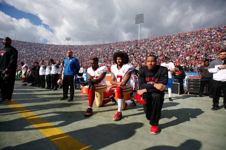 Colin Kaepernick (middle) and two teammates kneel during the national anthem last December before a football game in Los Angeles.