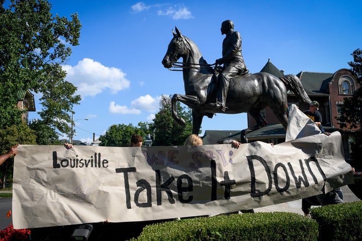 Members of a racial justice organization prepare to hang a banner on a monument to Confederate soldier John B. Castleman in Louisville, Kentucky, on Aug. 19, 2017.