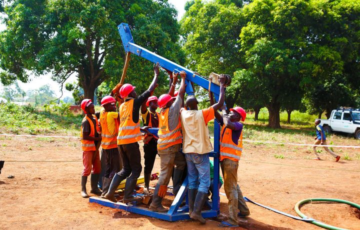 Julien (in gray) and the rest of Concern’s team assemble a mobile drilling kit or “village drill,” which is used to provide new water sources for conflict-affected communities in Kouango, Central African Republic.