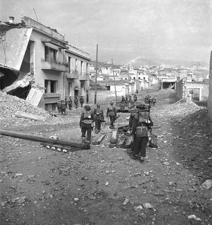 British troops clear the streets among bomb-damaged buildings during the last stages of fighting in Athens