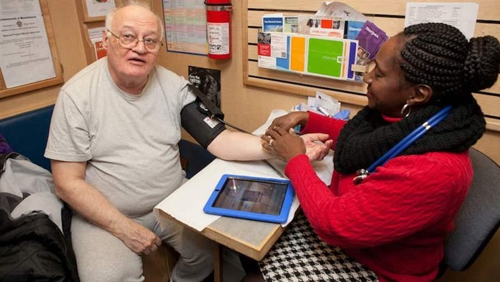 Rainelle Walker-White, assistant director of the Family Van in Boston, takes a patient’s blood pressure aboard the mobile hea